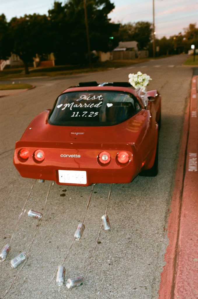Old red corvette bride and groom getaway car