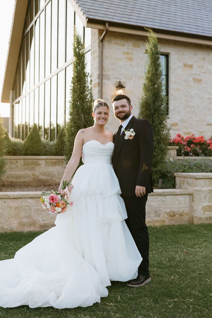 Bride and groom smiling outdoors during wedding portraits at The Bower venue in Edmond, OK.