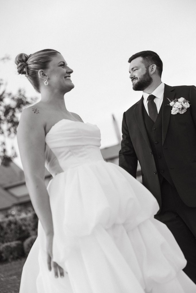 Black and white close-up portrait of bride in strapless tulle wedding gown and groom in suit outdoors at The Bower in Edmond, Oklahoma.
