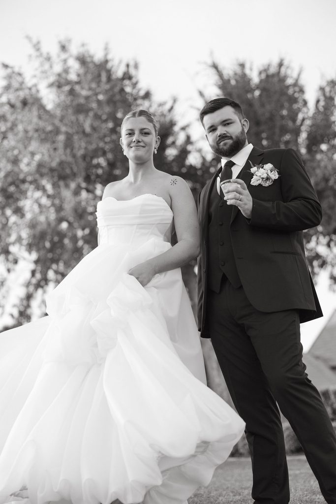 Black and white portrait of bride and groom smiling together outdoors during wedding reception at The Bower in Edmond, OK.