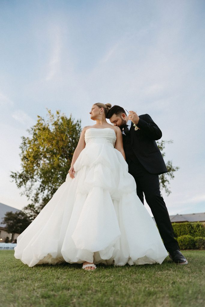 Romantic outdoor wedding portrait of bride and groom against open sky at The Bower wedding venue in Edmond, OK.