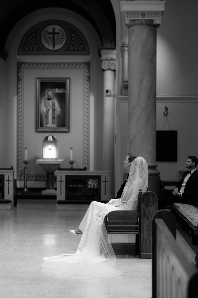 Moody bride and groom shot seated in cathedral
