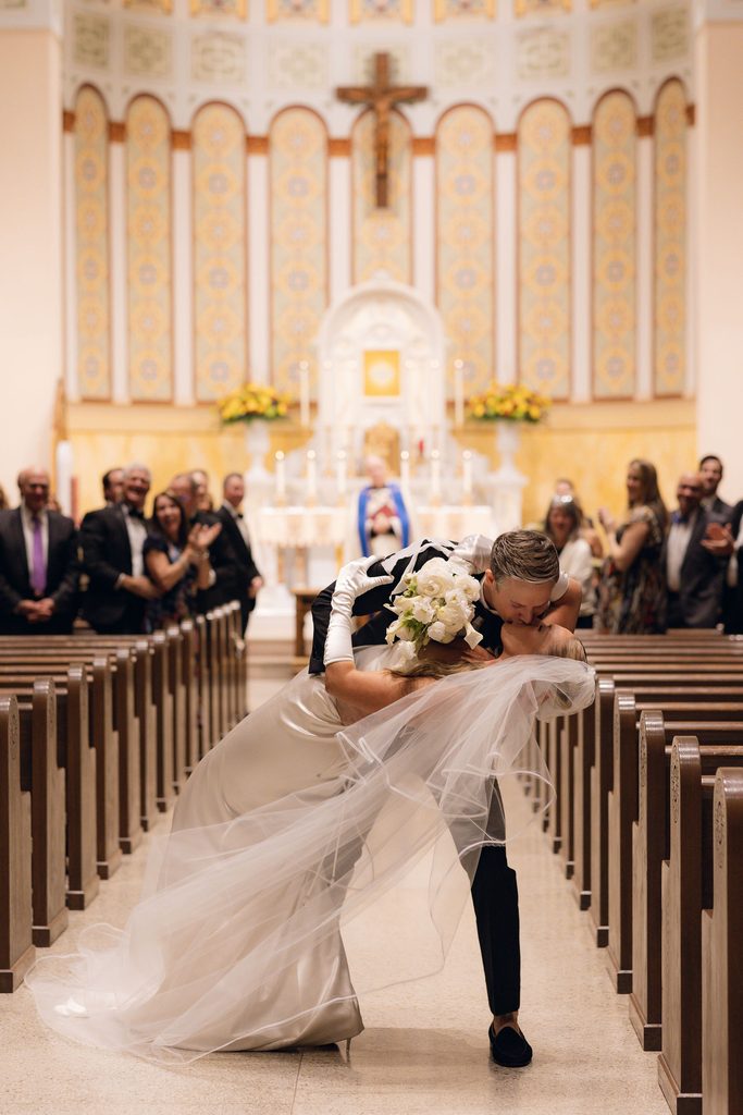 Aisle kiss after wedding ceremony in beautiful cathedral