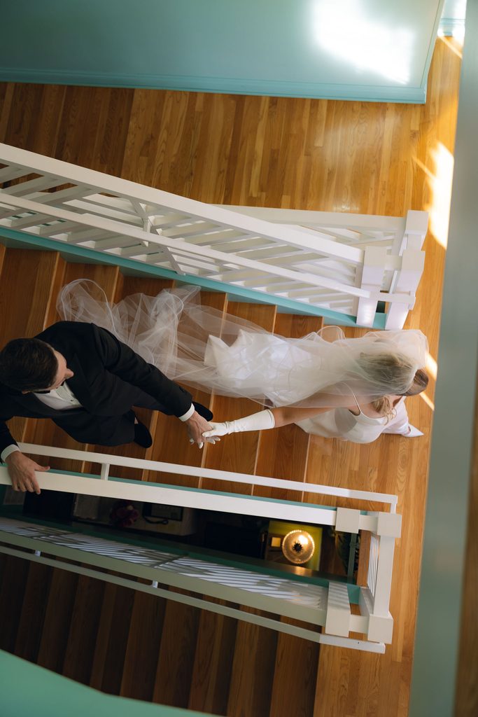 Bride and groom walking down staircase at Bradford House in Oklahoma City